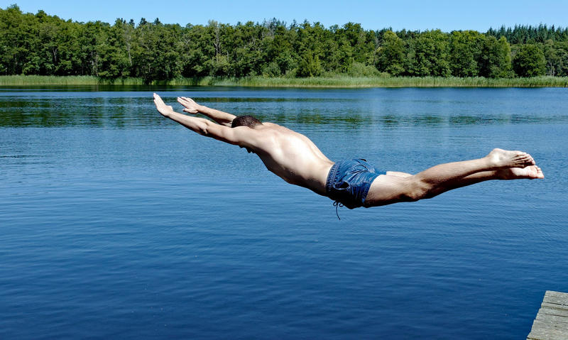 Abbildung eines Mannes, der in einen See springt.