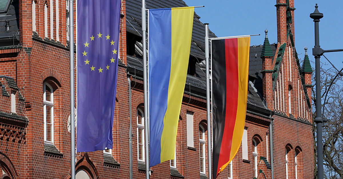 Die Flaggen der Europäischen Union, der Ukraine und der Bundesrepublik Deutschland vor der Kreisverwaltung in Beeskow.
