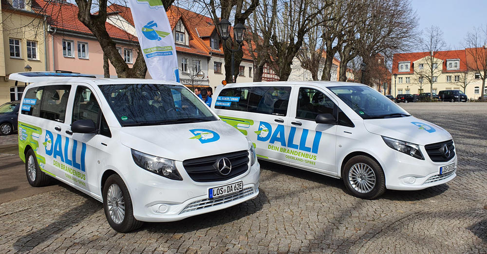 Die beiden Fahrzeuge des innovativen Verkehrsprojektes "DALLI" auf dem Marktplatz in Storkow. (Mark).