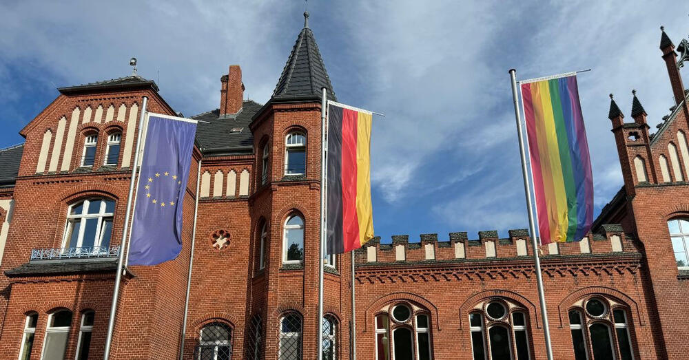 Verwaltungsgeb&auml;ude mit gehisster Europa-, Deutschland- und Regenbogenfahne