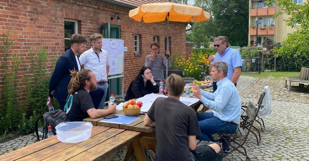 Amtsleiter Oliver K&uuml;hne sitzt mit f&uuml;nf weiteren Perosnen an einem Tisch zusammen