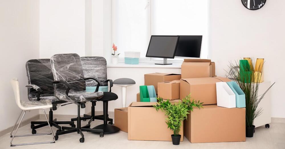 Umzugskartons, eingepackte B&uuml;rost&uuml;hle, Bildschirme, B&uuml;romaterialen und Zimmerpflanzen warten auf den Abtransport
