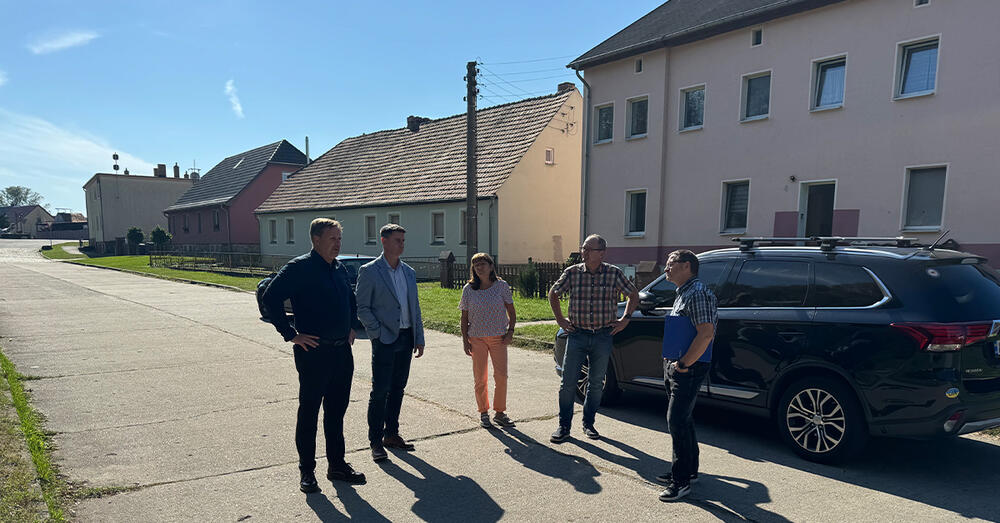 Landrat Frank Steffen steht zusammen mit einigen Personen In der Seestra&szlig;e in Brieskow-Finkenheerd