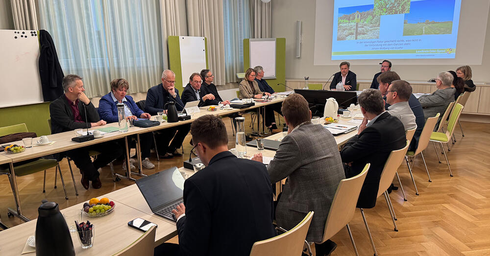 Amtsdirekturen und B&uuml;rgermeister sitzen in der Beratung am Tisch. Landrat Frank Steffen stellt Projekte vor.