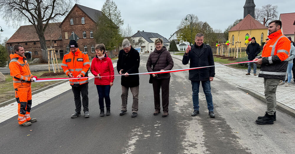 Michael Buhrke, Dezernent f&uuml;r Innenverwaltung, Bauen und Kreisentwicklung, Maik Koschack, B&uuml;rgermeister der Stadt Friedland, Silke Bernhard, Ortsvorsteherin in Reudnitz und Stra&szlig;enplanerin Ulrike Ha&szlig; schneiden das rot-wei&szlig;e Band zur einweihung der Strasse durch.