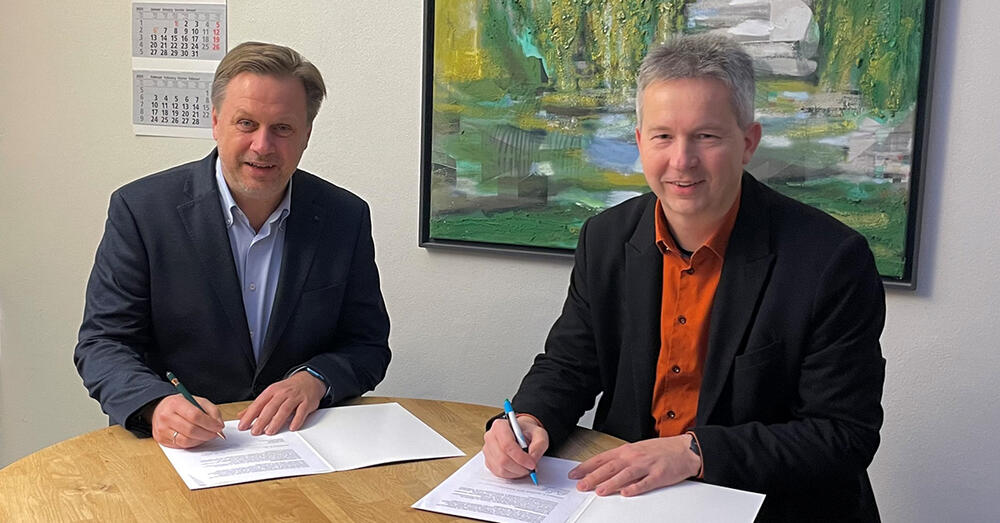 Landrat Frank Steffen und B&uuml;rgermeister Ralf Steinbr&uuml;ck unterzeichnen die Kooperationsvereinbarung.