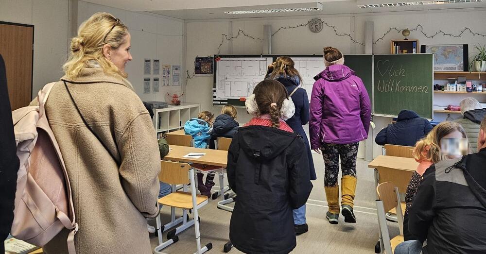 Sch&uuml;ler stehen gemeinsam mit ihre Eltern beim Tag der offenen T&uuml;r in einem Klassenraum des Gymnasiums in Sch&ouml;neiche.