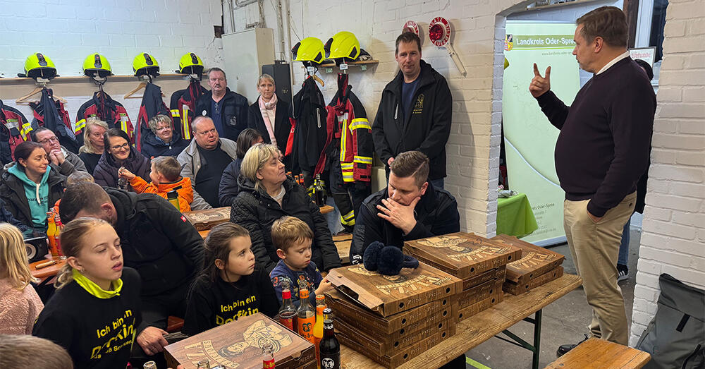 Das Talk-Format "Frag' den Landrat" im Feuerwehrhaus Gro&szlig; Schauen mit vielen Kindern und Erwachsenen die sitzend den Ausf&uuml;hrungen von Landrat Frank Steffen zuh&ouml;ren.