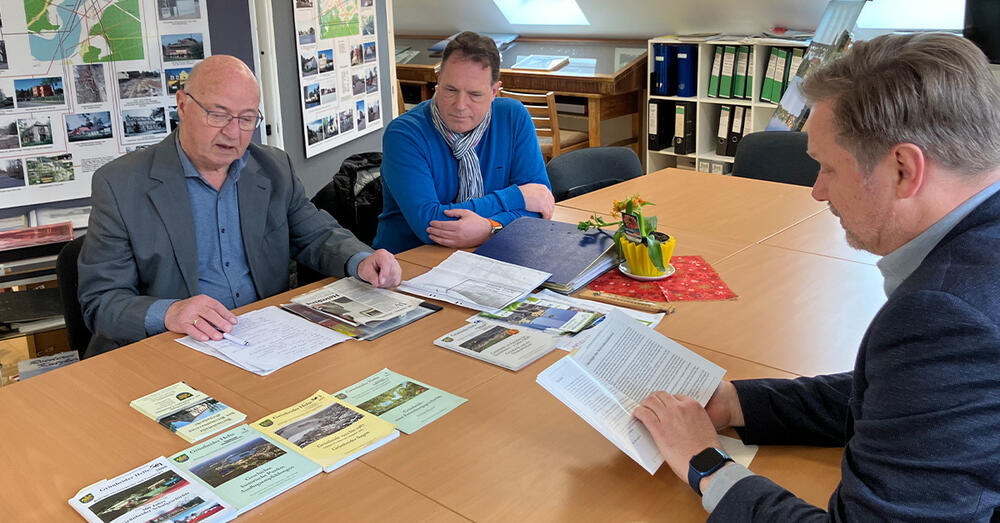 Die Vorstandsmitglieder des Heimatvereins Lothar Runge und Thomas W&ouml;tzel erkl&auml;ren Frank Steffen die Hintergr&uuml;nde zu einem KZ-Au&szlig;enlager in Gr&uuml;nheide