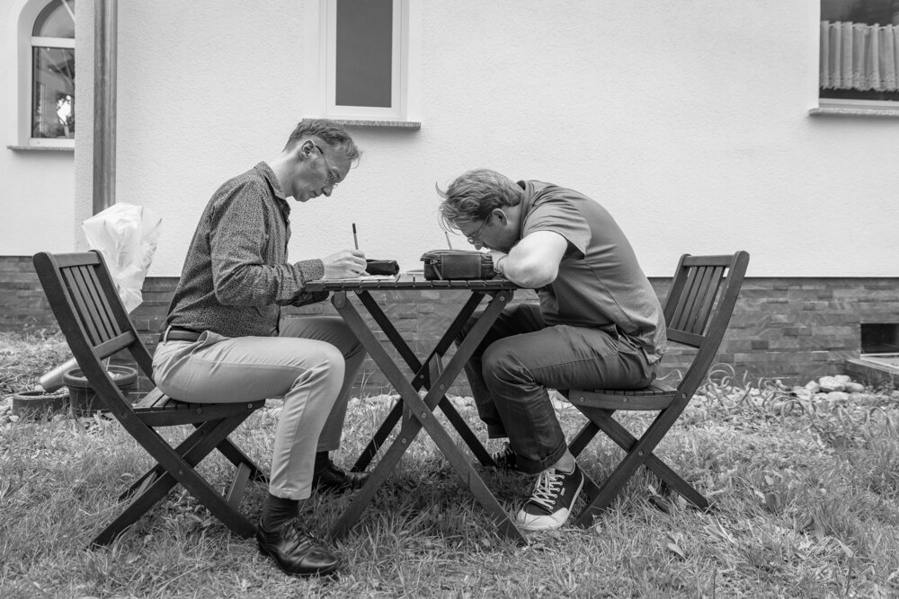 Olav Amende und Jascha Riesselmann beim Schreiben Postkartensammlung w&auml;hrend ihres Aufenthalts in Rauen.
(hier bitte noch die Zeilenschaltung nach "Gegengef&auml;lle" l&ouml;schen)